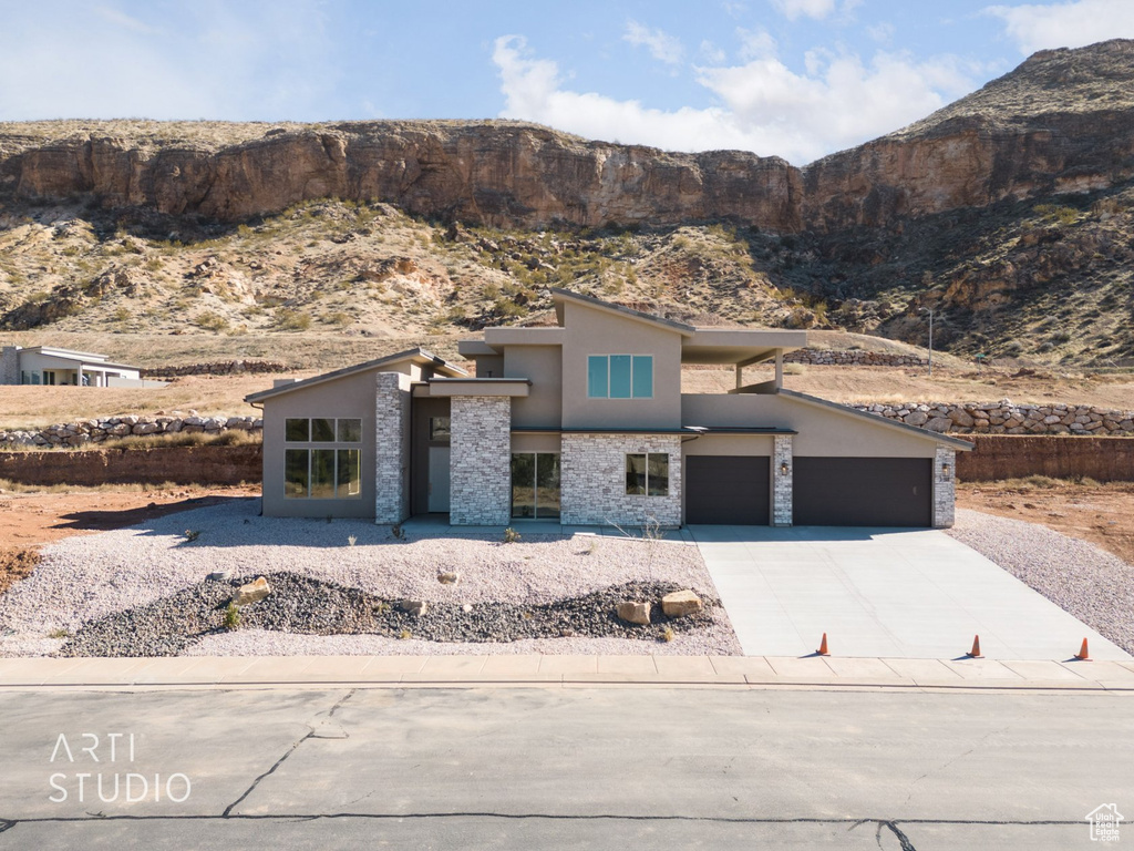 View of front facade featuring a garage and a mountain view