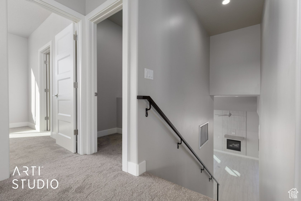 Stairway featuring light carpet and ceiling fan