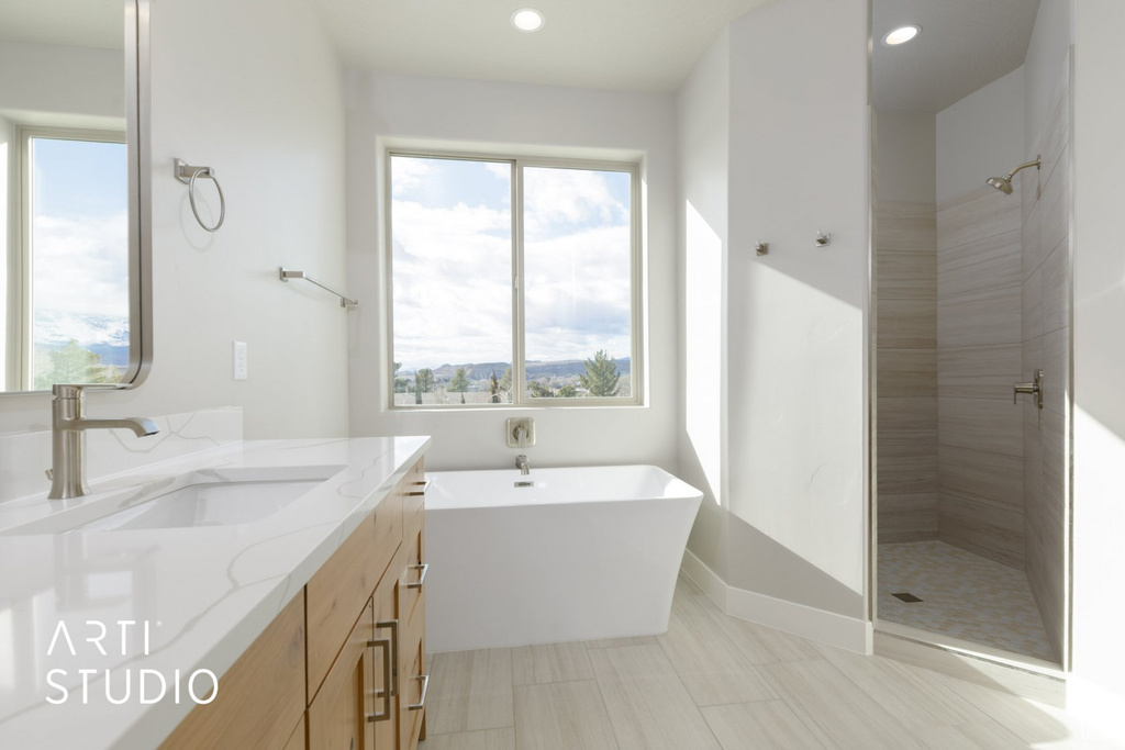 Bathroom with vanity, tile flooring, and shower with separate bathtub