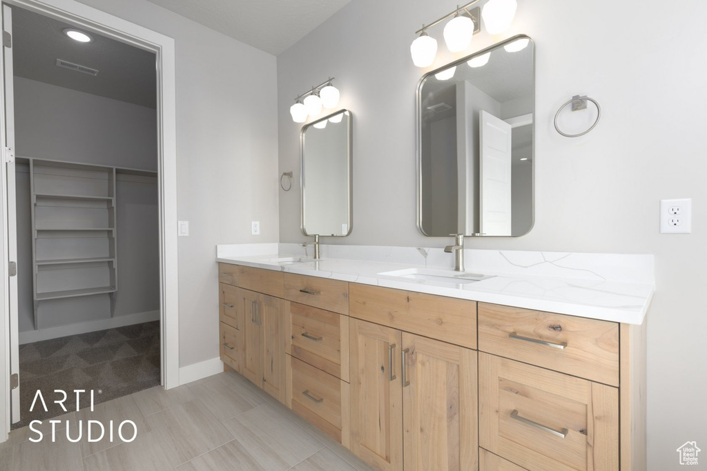 Bathroom featuring dual bowl vanity and tile flooring