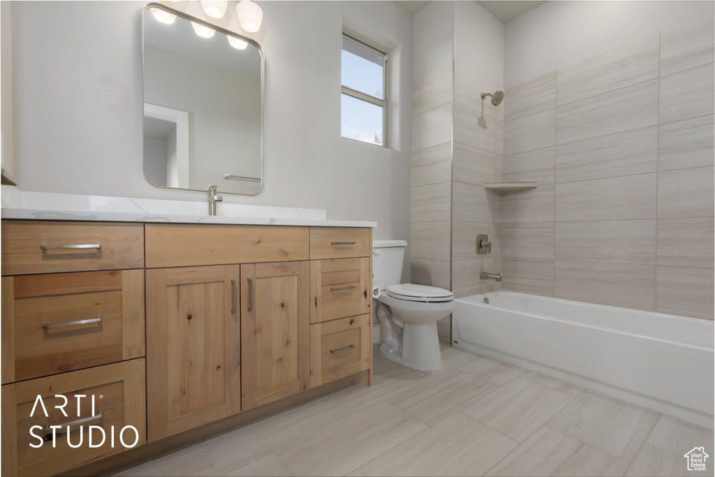 Full bathroom with tiled shower / bath, vanity, tile flooring, and toilet