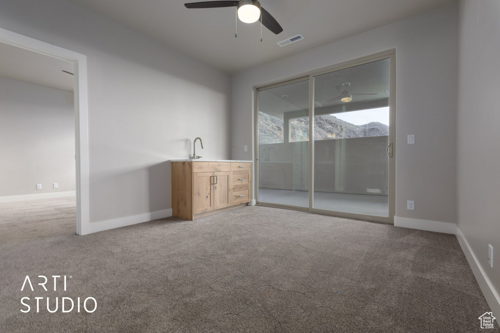 Unfurnished room featuring ceiling fan and light carpet