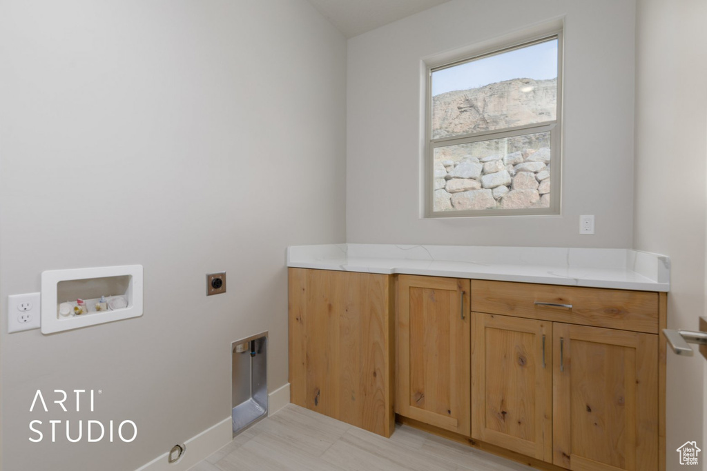 Laundry room featuring cabinets, light tile flooring, washer hookup, and hookup for an electric dryer