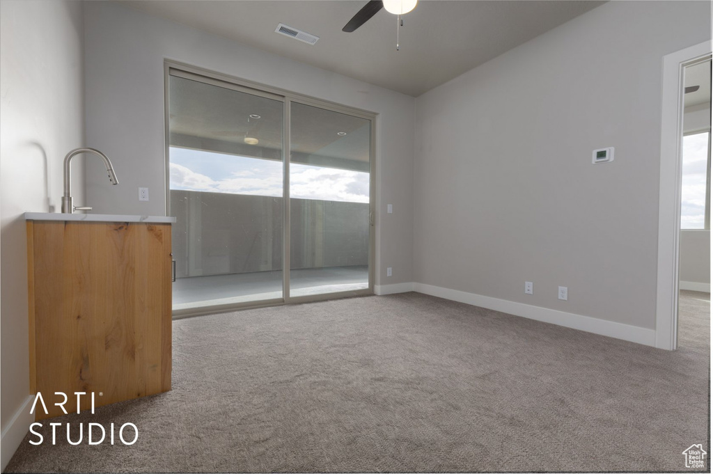 Empty room featuring light carpet and ceiling fan