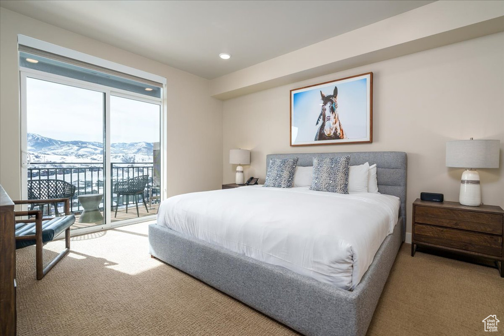 Bedroom featuring a mountain view, light colored carpet, and access to outside