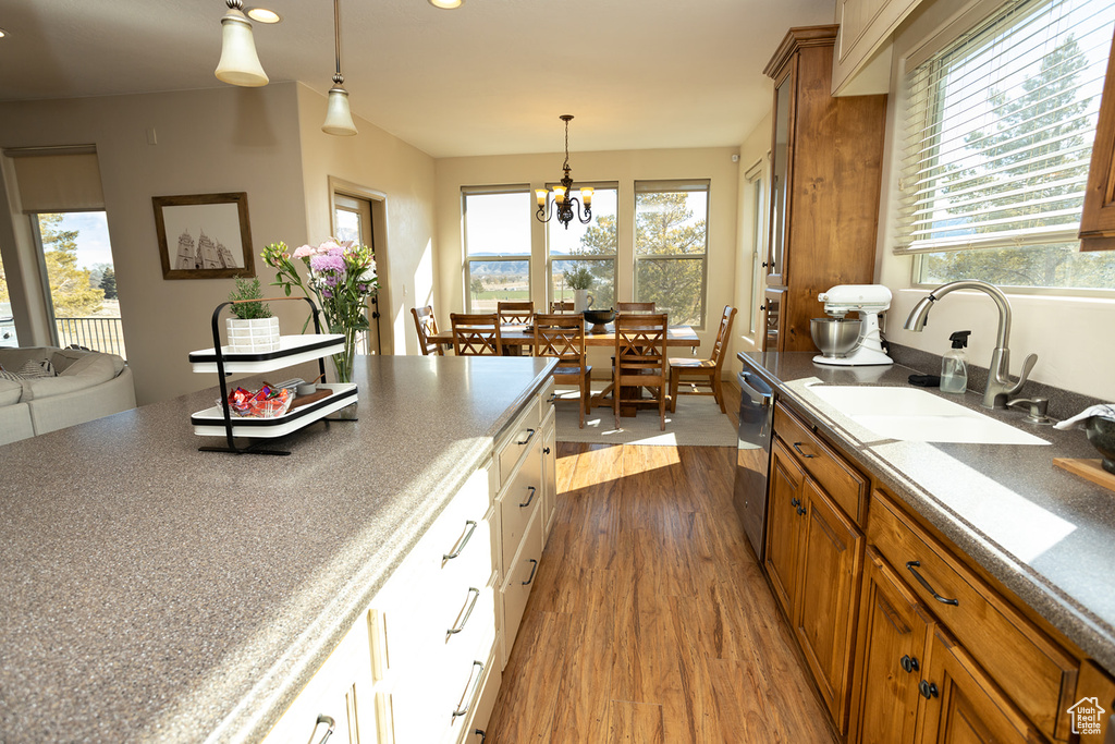 Kitchen featuring white cabinets, dark hardwood / wood-style floors, hanging light fixtures, and a healthy amount of sunlight