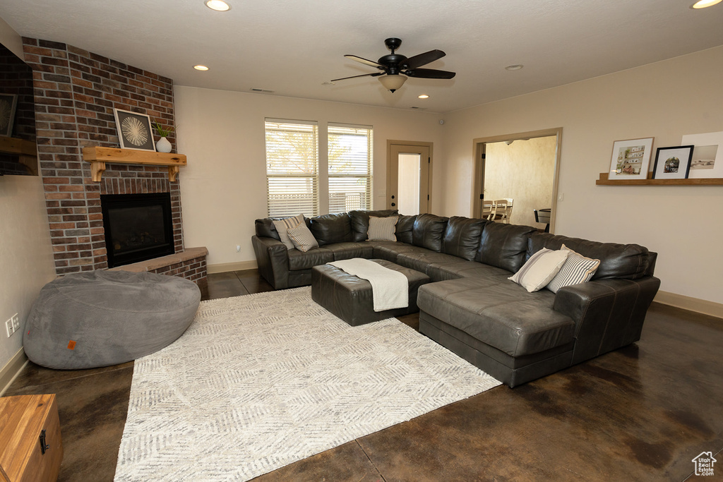 Living room with brick wall, a brick fireplace, and ceiling fan