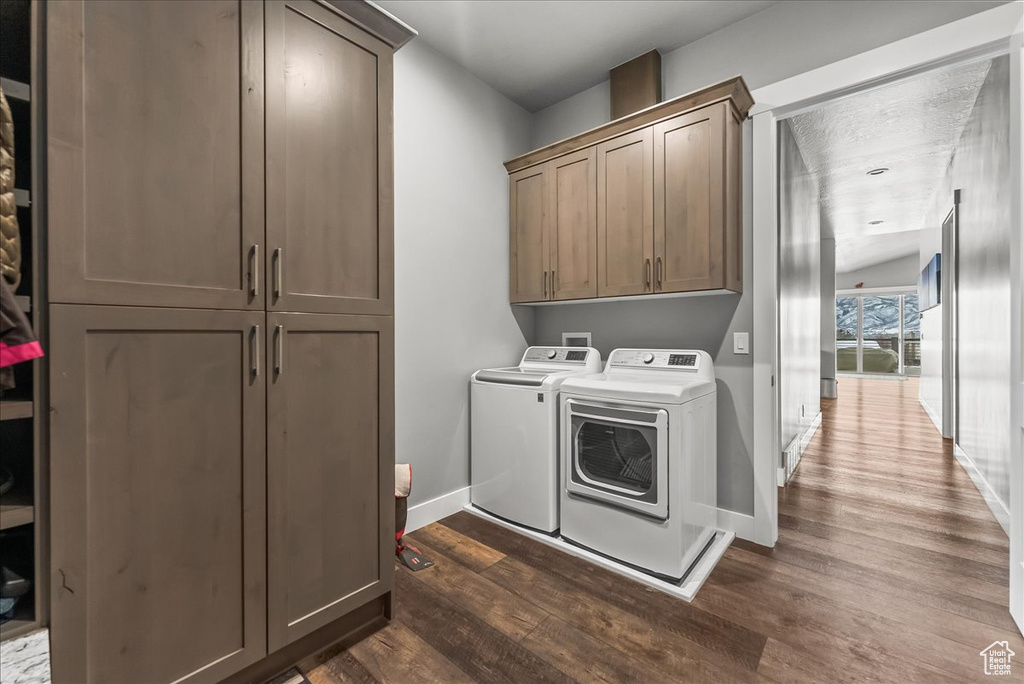 Laundry area with dark hardwood / wood-style flooring, cabinets, hookup for a washing machine, and independent washer and dryer