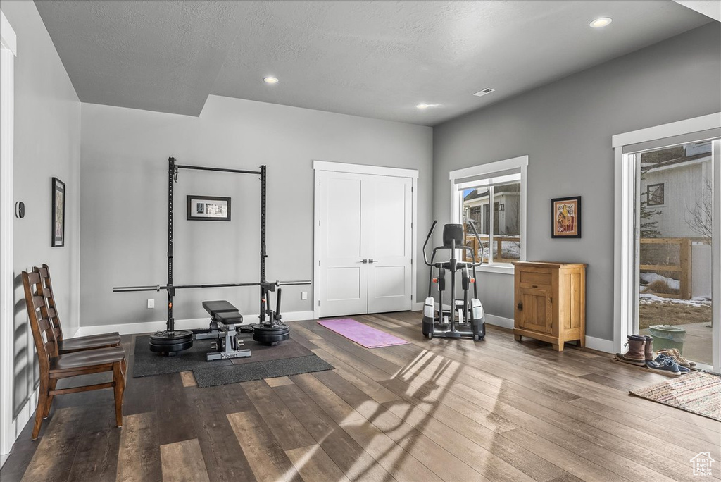 Workout area with dark hardwood / wood-style flooring