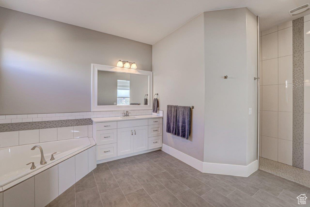 Bathroom featuring vanity, tile floors, and a washtub