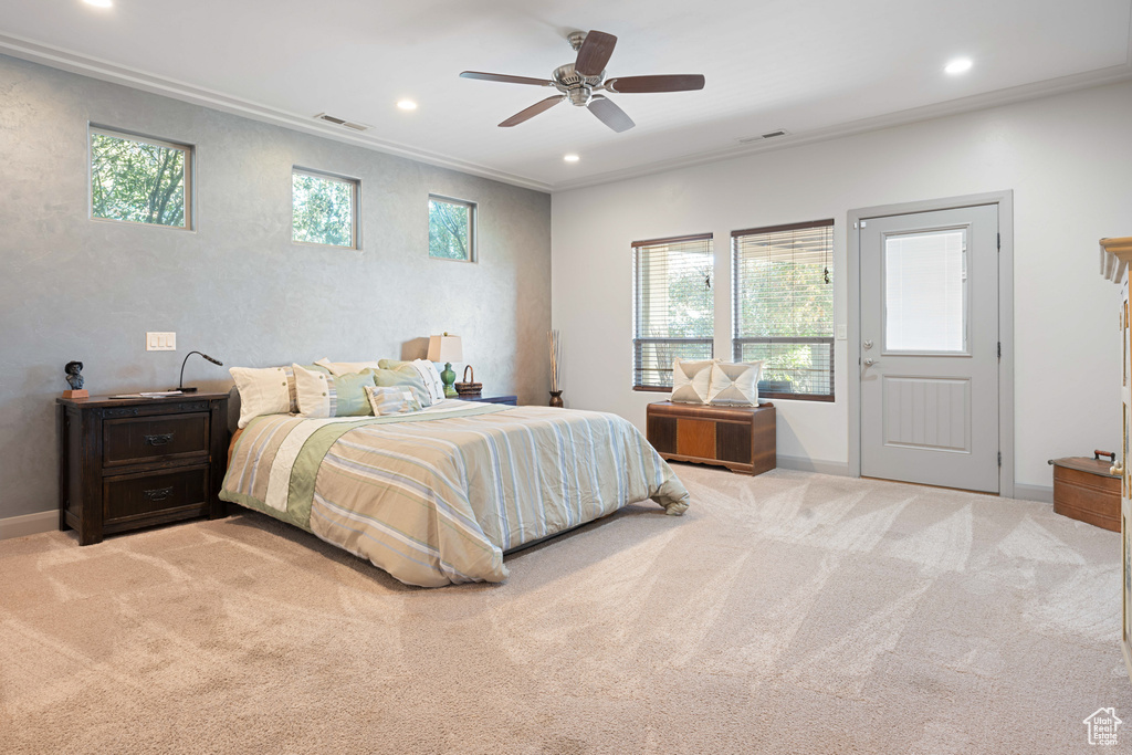 Bedroom with multiple windows, crown molding, ceiling fan, and light carpet