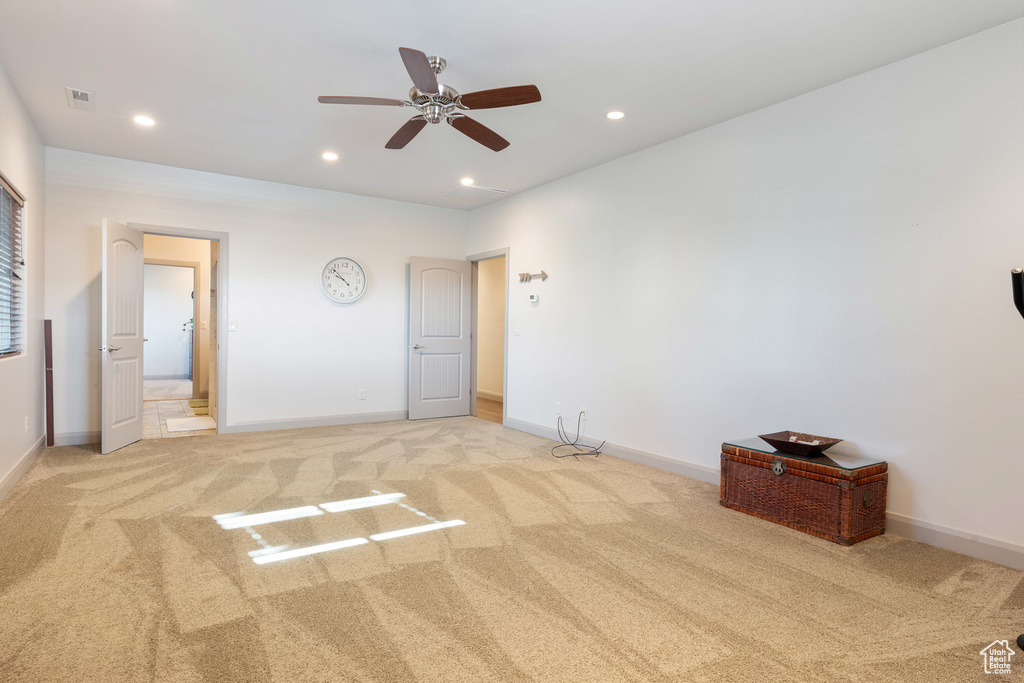 Unfurnished bedroom featuring ensuite bathroom, ceiling fan, and light colored carpet
