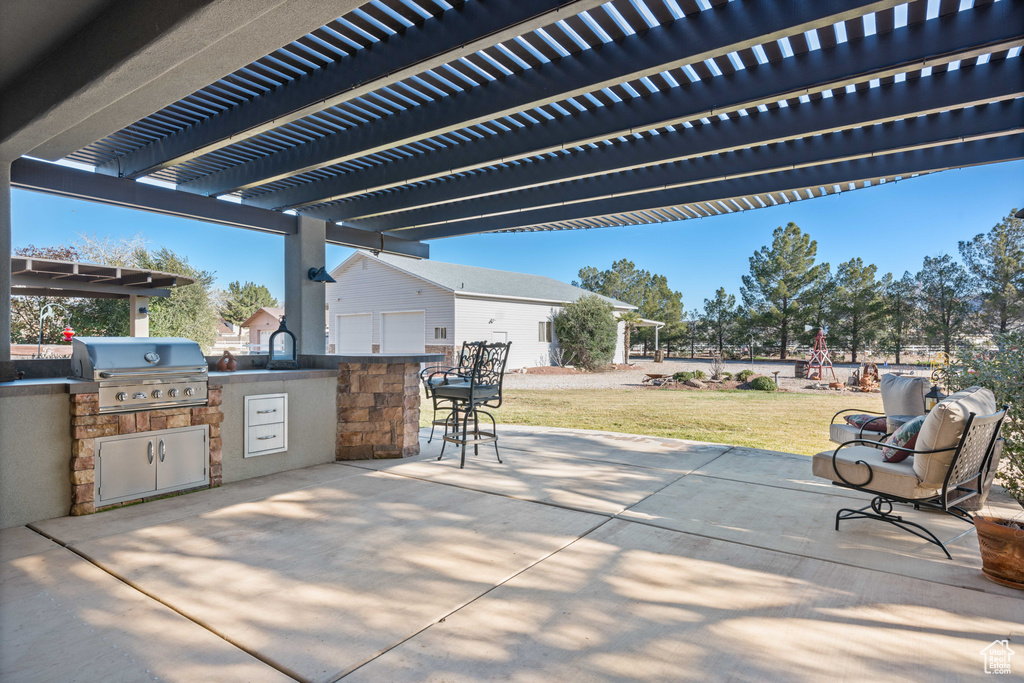 View of terrace with exterior kitchen, area for grilling, and a pergola
