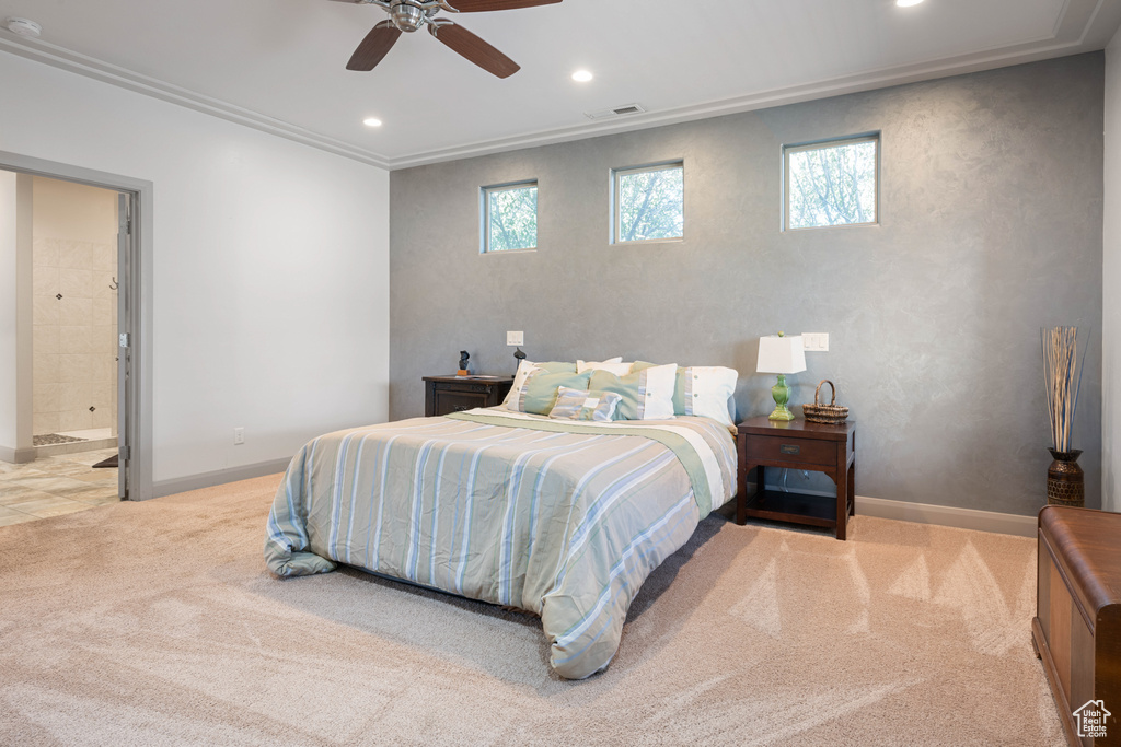 Carpeted bedroom featuring ceiling fan, ensuite bathroom, and ornamental molding