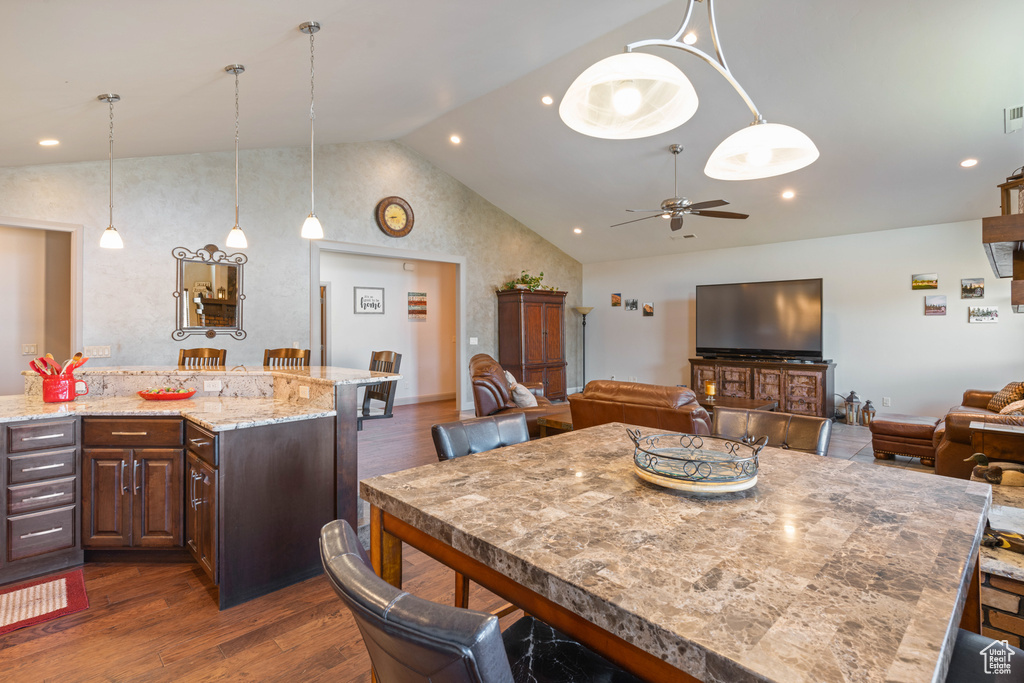 Dining space featuring dark hardwood / wood-style floors, ceiling fan, and high vaulted ceiling