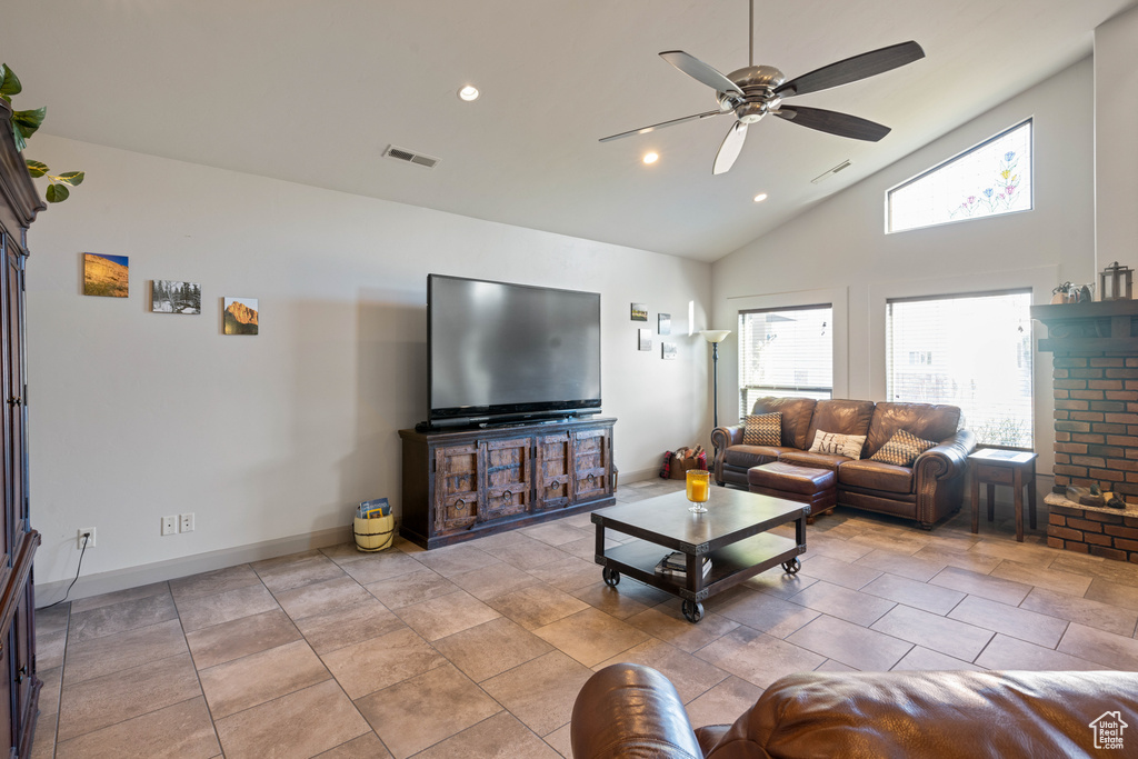 Living room featuring high vaulted ceiling, ceiling fan, and light tile floors
