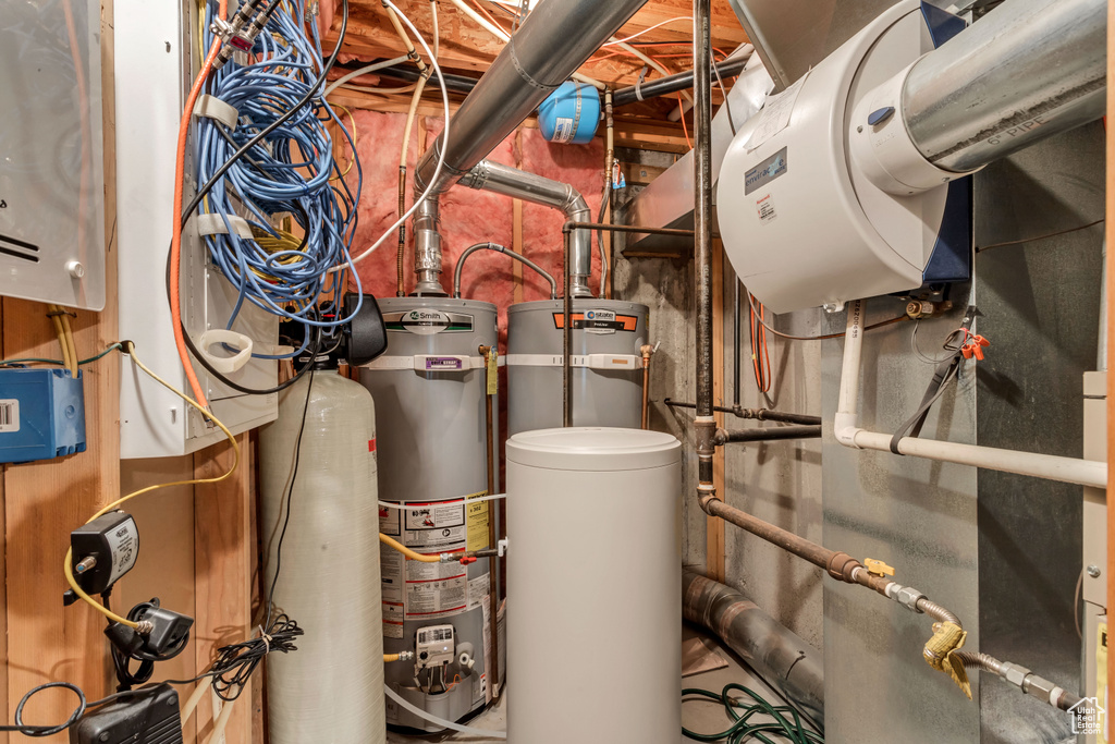 Utility room featuring water heater and strapped water heater