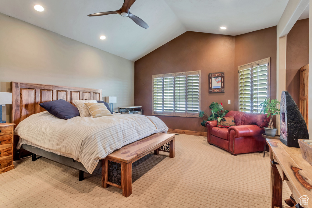Bedroom with ceiling fan, light carpet, and high vaulted ceiling