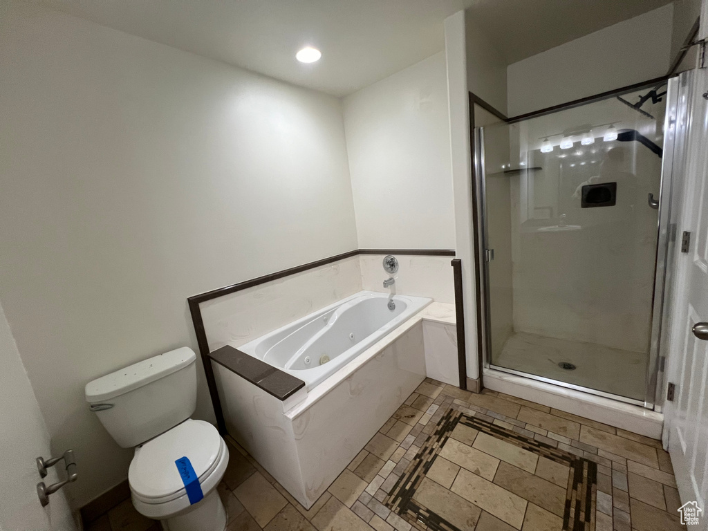 Bathroom with tile floors, separate shower and tub, and toilet