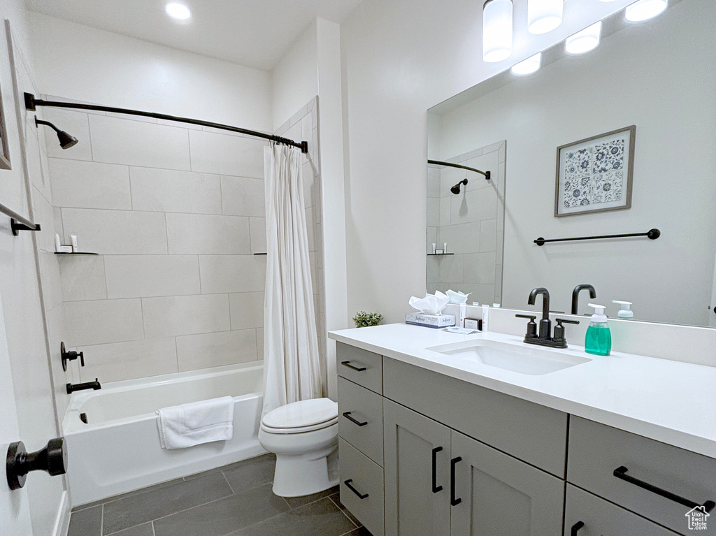 Full bathroom with shower / bathtub combination with curtain, vanity, tile flooring, and toilet