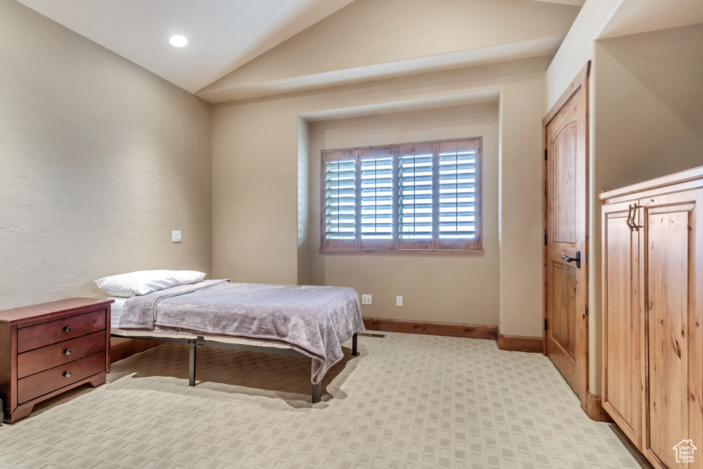 Carpeted bedroom with lofted ceiling