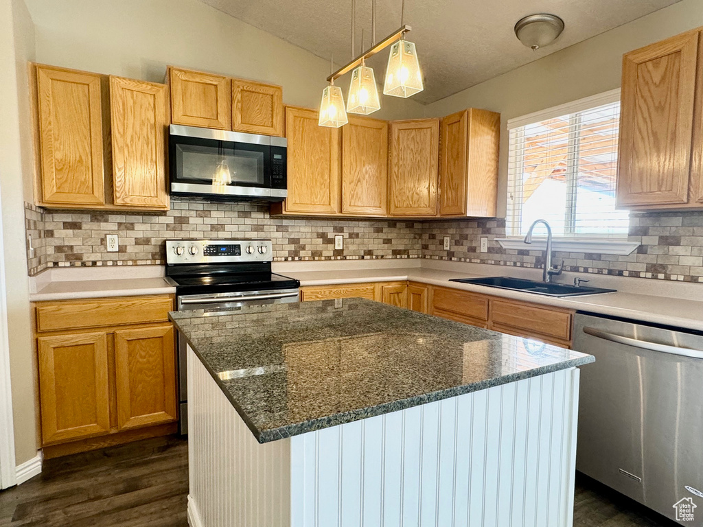Kitchen featuring lofted ceiling, backsplash, dark wood-type flooring, sink, and stainless steel appliances