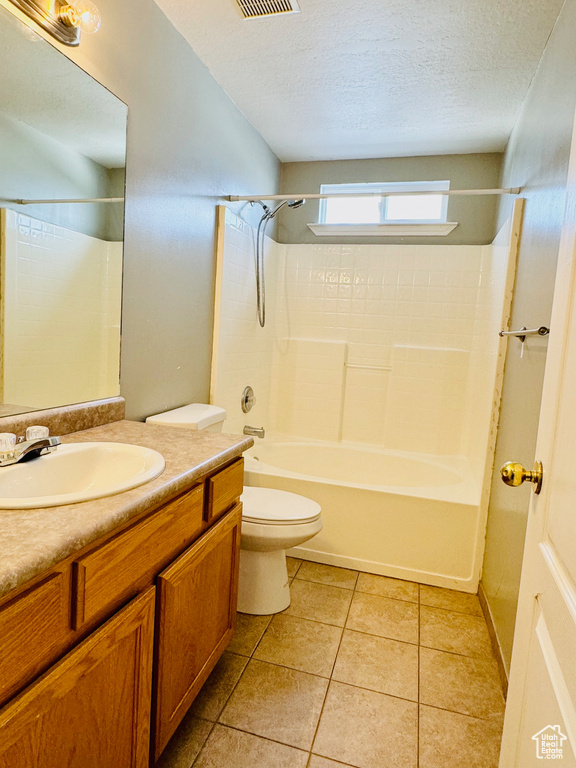 Full bathroom with shower / bath combination, vanity, a textured ceiling, and toilet