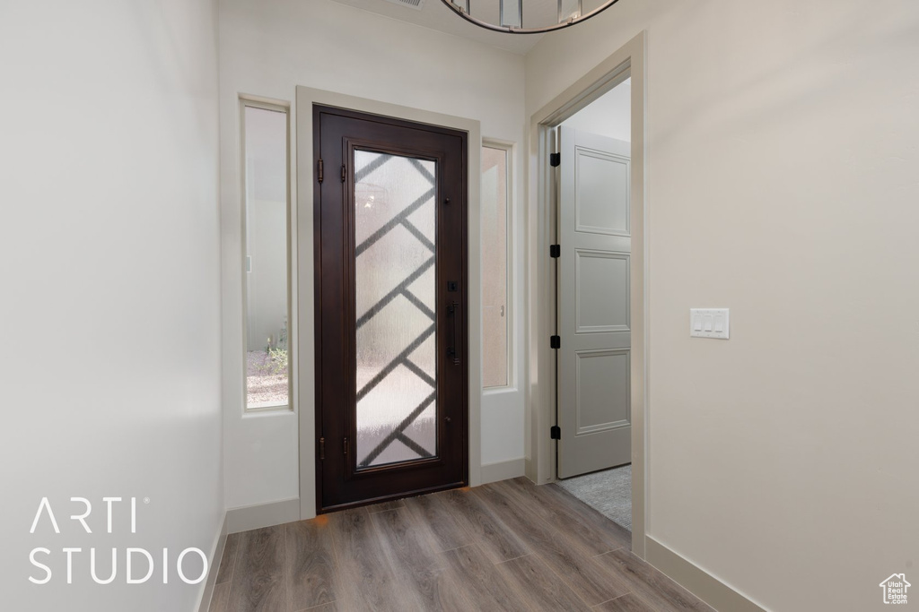 Foyer entrance with an inviting chandelier and light hardwood / wood-style floors