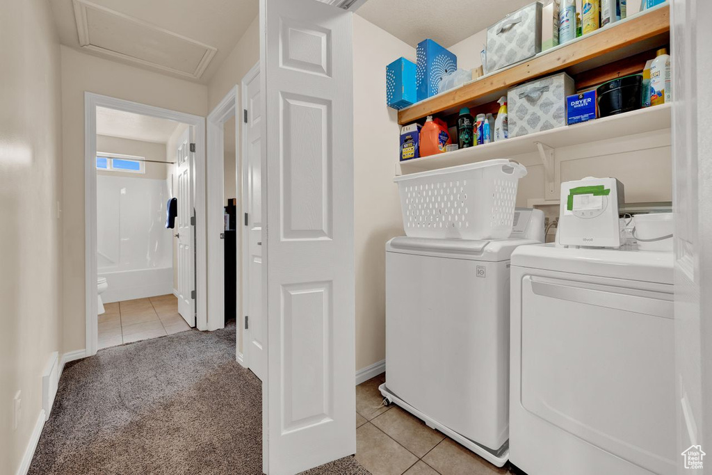 Washroom featuring washer and clothes dryer and light carpet