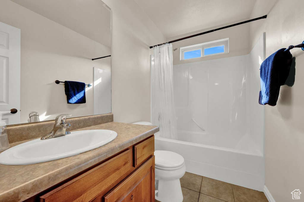 Full bathroom featuring toilet, tile floors, shower / tub combo with curtain, and oversized vanity