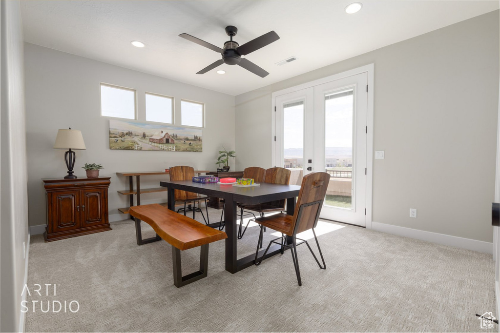 Carpeted dining room with french doors, ceiling fan, and a healthy amount of sunlight