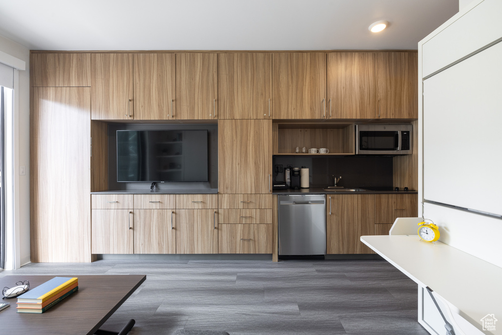 Kitchen featuring appliances with stainless steel finishes, dark hardwood / wood-style flooring, and sink