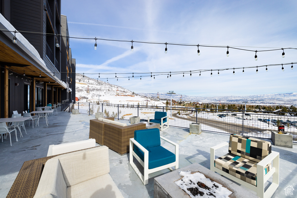 Snow covered patio with a mountain view and an outdoor living space