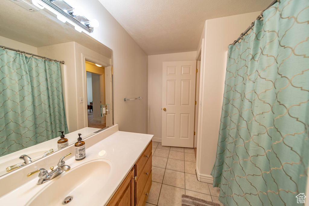 Bathroom featuring vanity, tile flooring, and a textured ceiling