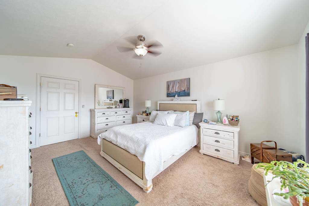 Bedroom with lofted ceiling, ceiling fan, and light colored carpet