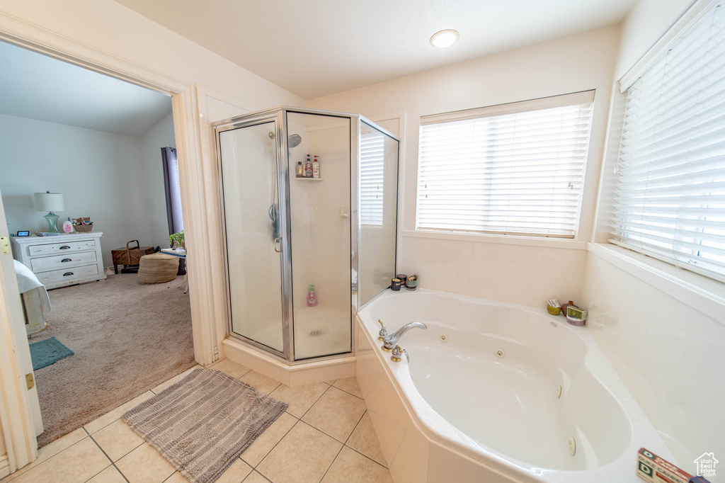 Bathroom featuring a wealth of natural light, tile floors, and plus walk in shower
