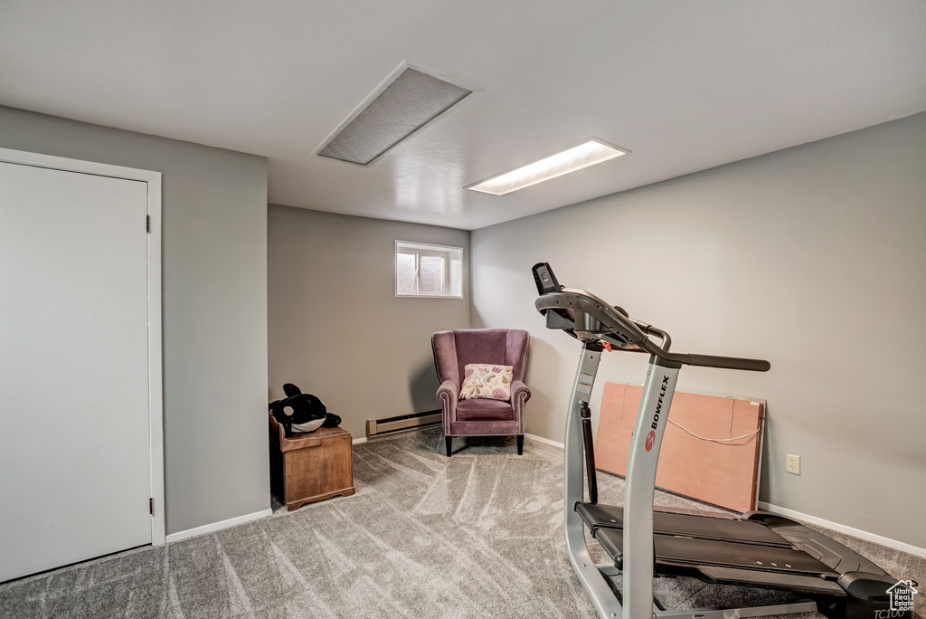 Workout room with baseboard heating and light colored carpet
