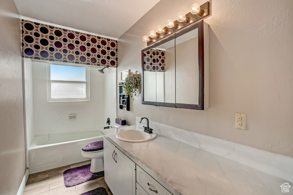 Full bathroom featuring toilet, tub / shower combination, and vanity with extensive cabinet space