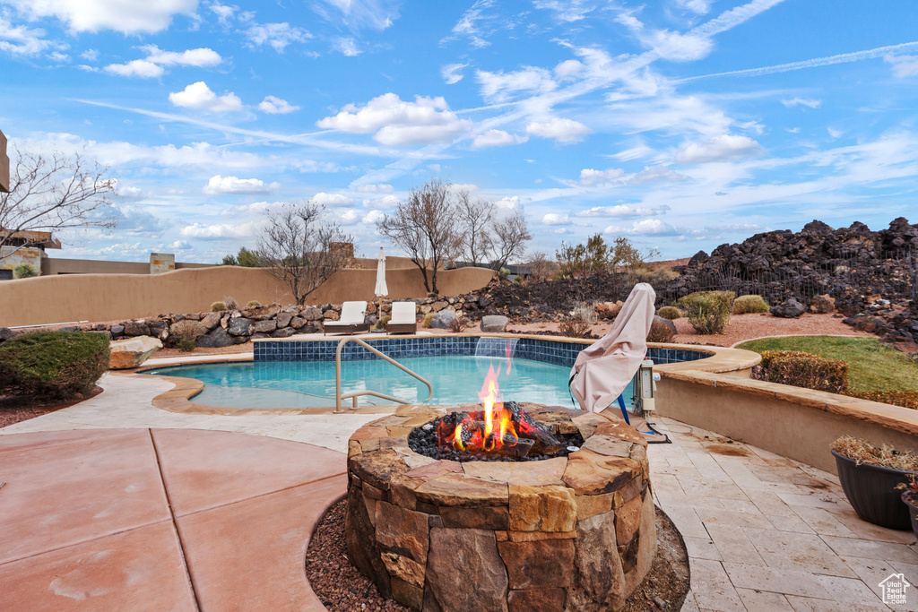 View of swimming pool featuring an outdoor fire pit and a patio area