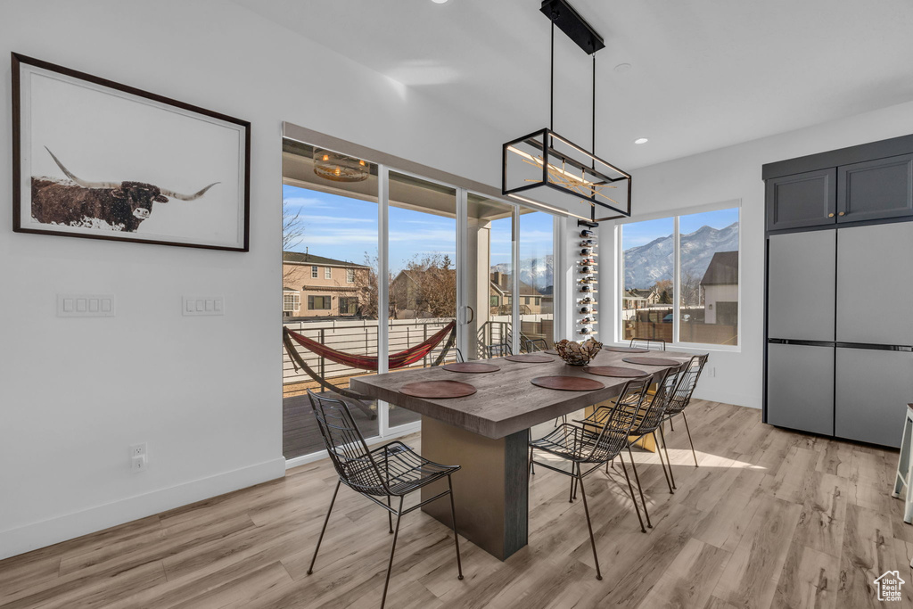 Dining area with a mountain view, light hardwood / wood-style flooring, and a notable chandelier