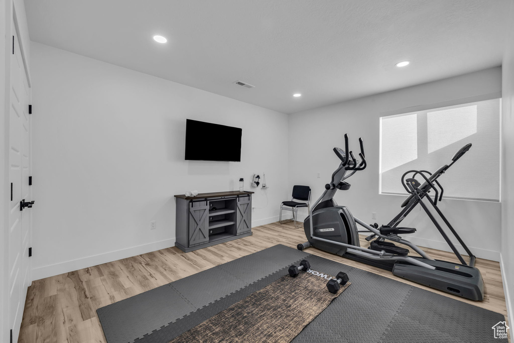 Workout room with light hardwood / wood-style floors