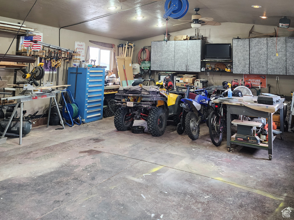 Garage with a garage door opener, a workshop area, and ceiling fan
