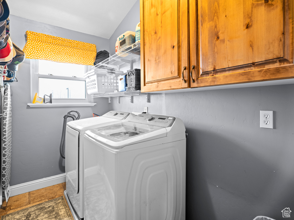 Laundry area with cabinets, washing machine and dryer, and tile floors