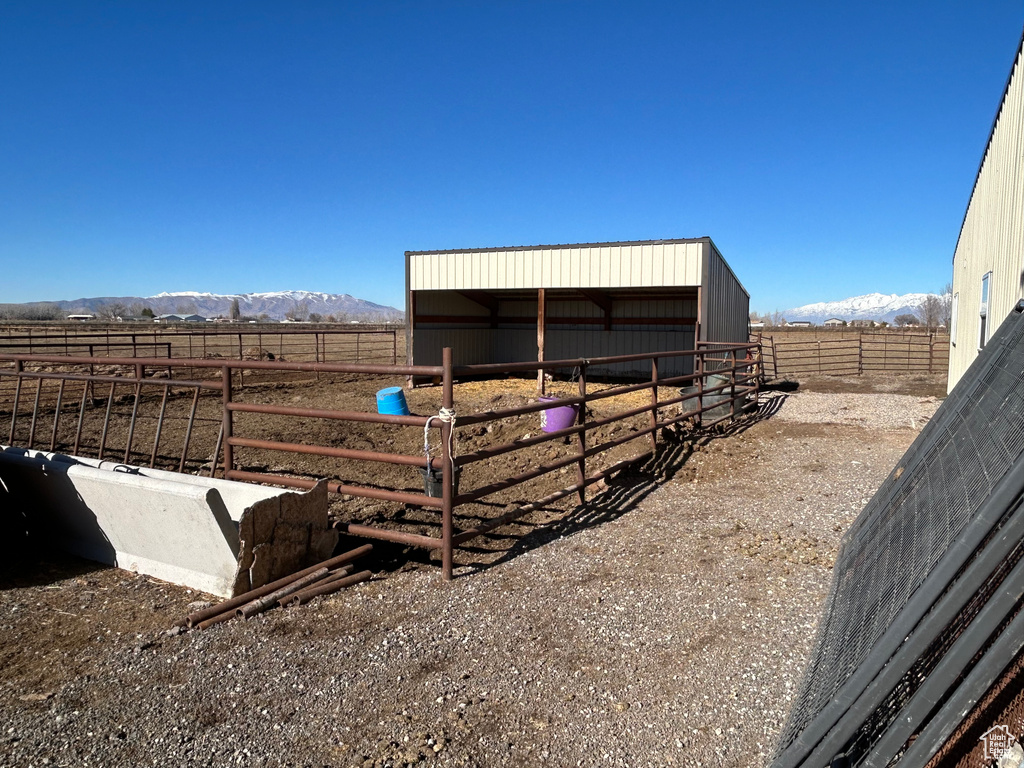 Exterior space with a rural view, an outdoor structure, and a mountain view