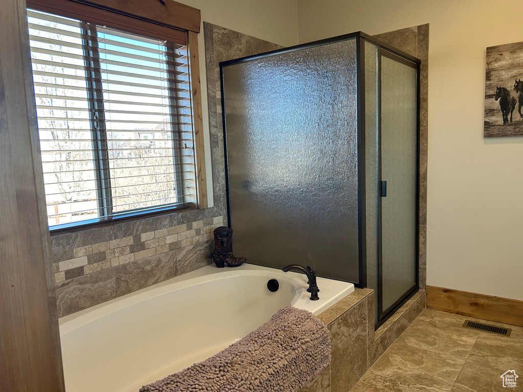Bathroom featuring tile floors and independent shower and bath