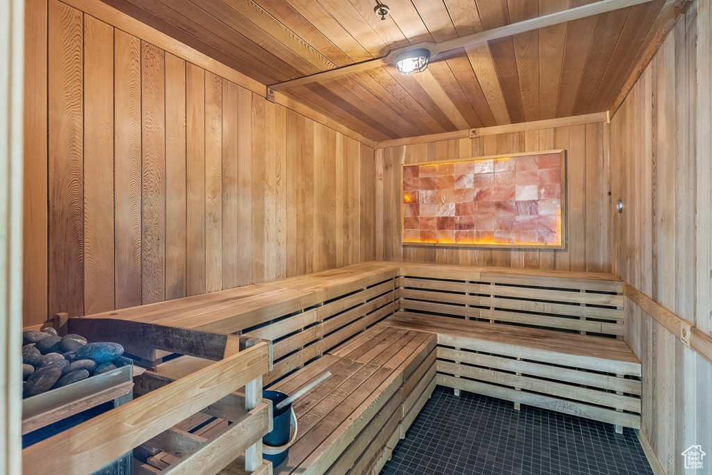View of sauna with wood ceiling, wood walls, and tile floors