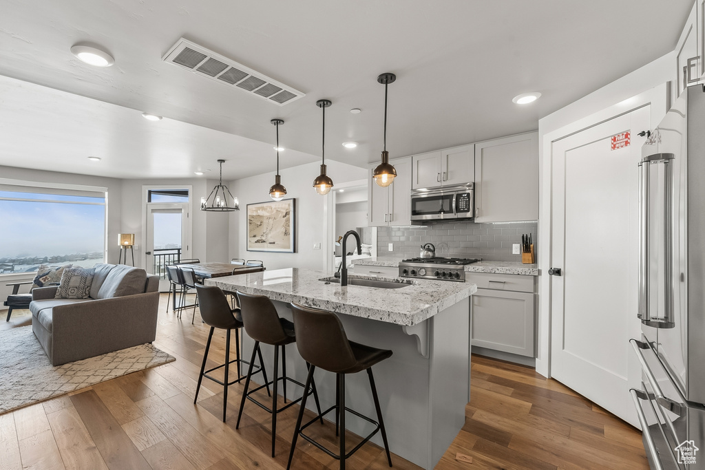 Kitchen with stainless steel appliances, white cabinetry, tasteful backsplash, sink, and dark hardwood / wood-style floors