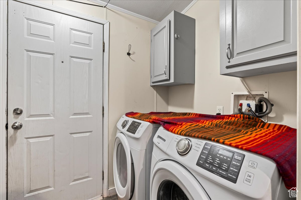 Clothes washing area with washer hookup, cabinets, ornamental molding, and independent washer and dryer