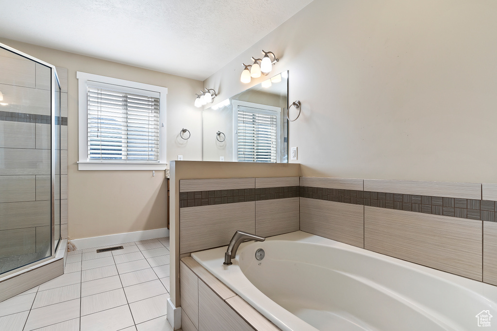 Bathroom featuring tile floors and separate shower and tub
