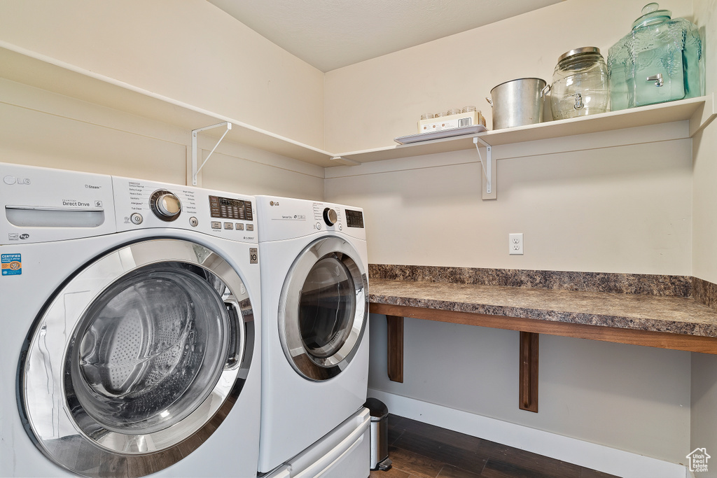 Clothes washing area featuring washer and dryer and dark hardwood / wood-style floors